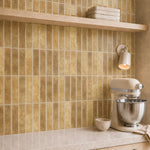 MORCART MT2208-XPE golden ochre vertical linear wall tiles, oblique kitchen detail with an oak shelf and cream mixer, fine mottled print and a shallow glossy finish.